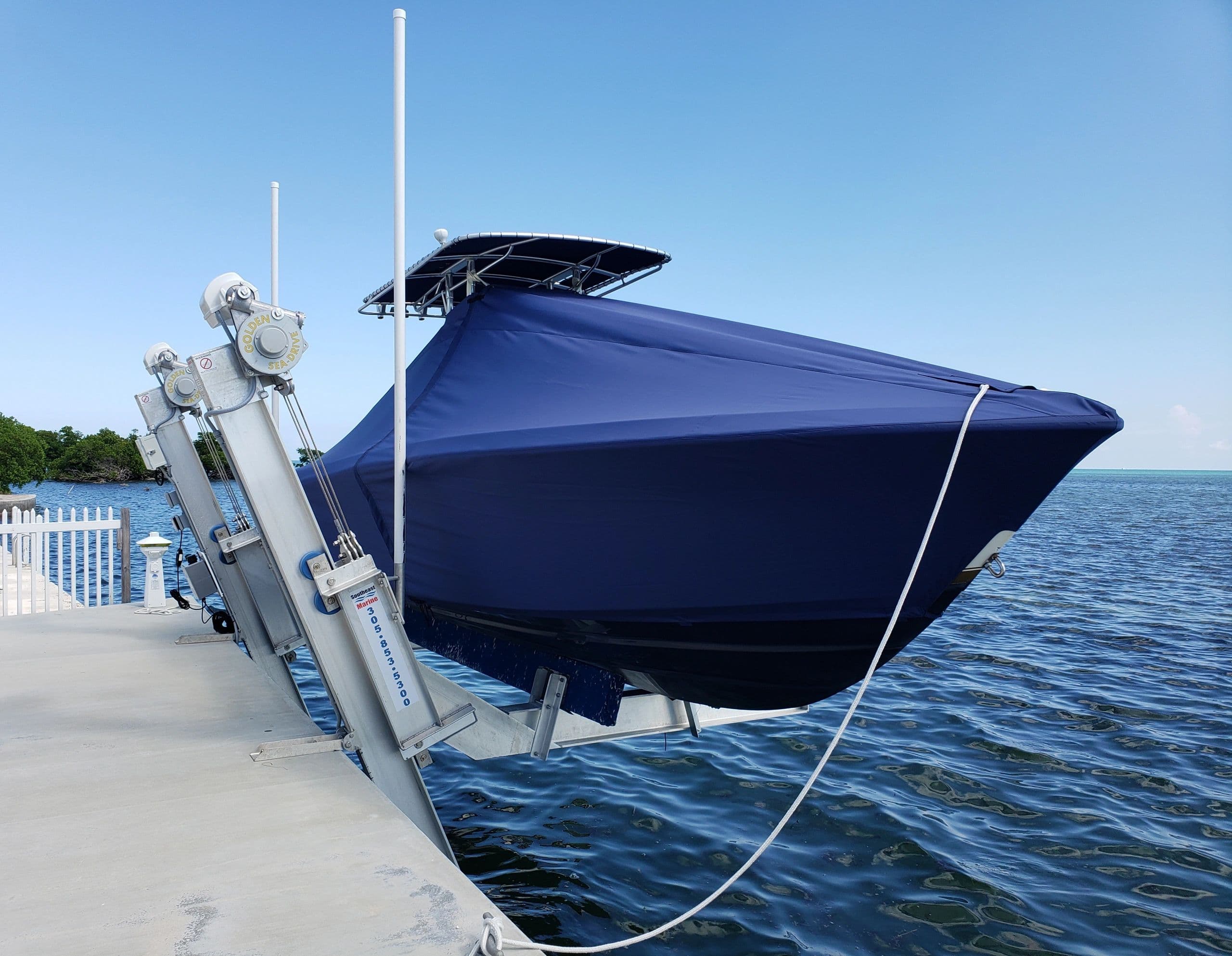Navy full boat cover fitted on a center console on the lift — Canvas Craft's own work