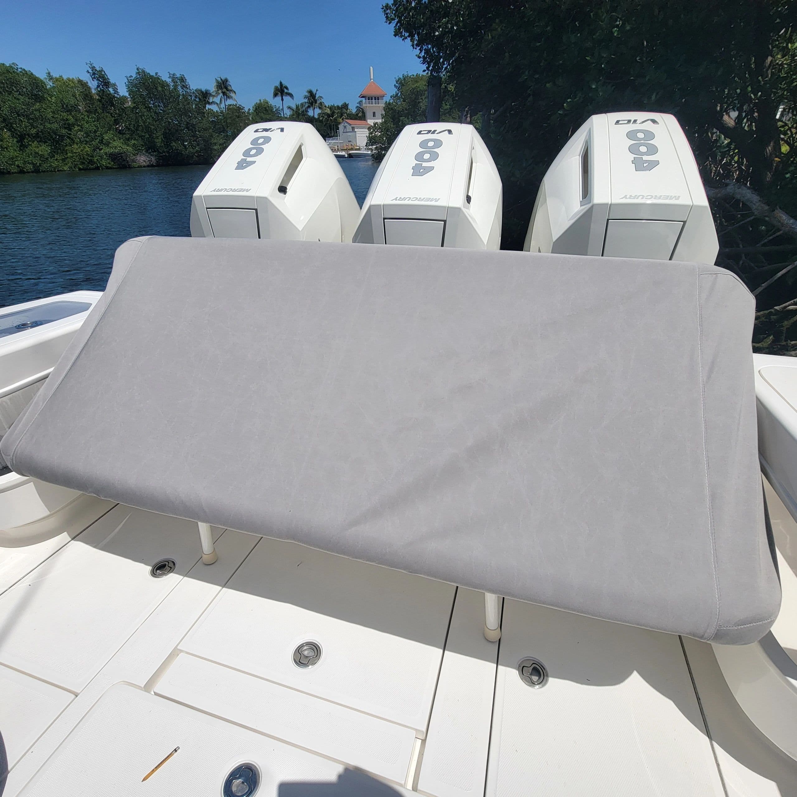 Fitted grey leaning-post cover with triple outboards behind