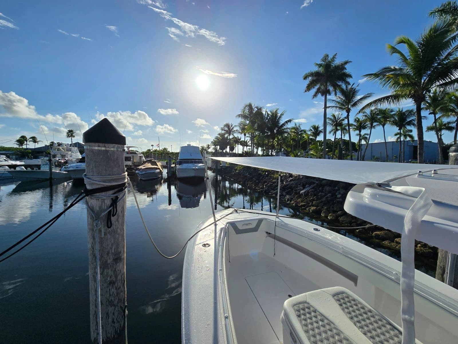 White bow shade rigged over a boat's foredeck at sunrise