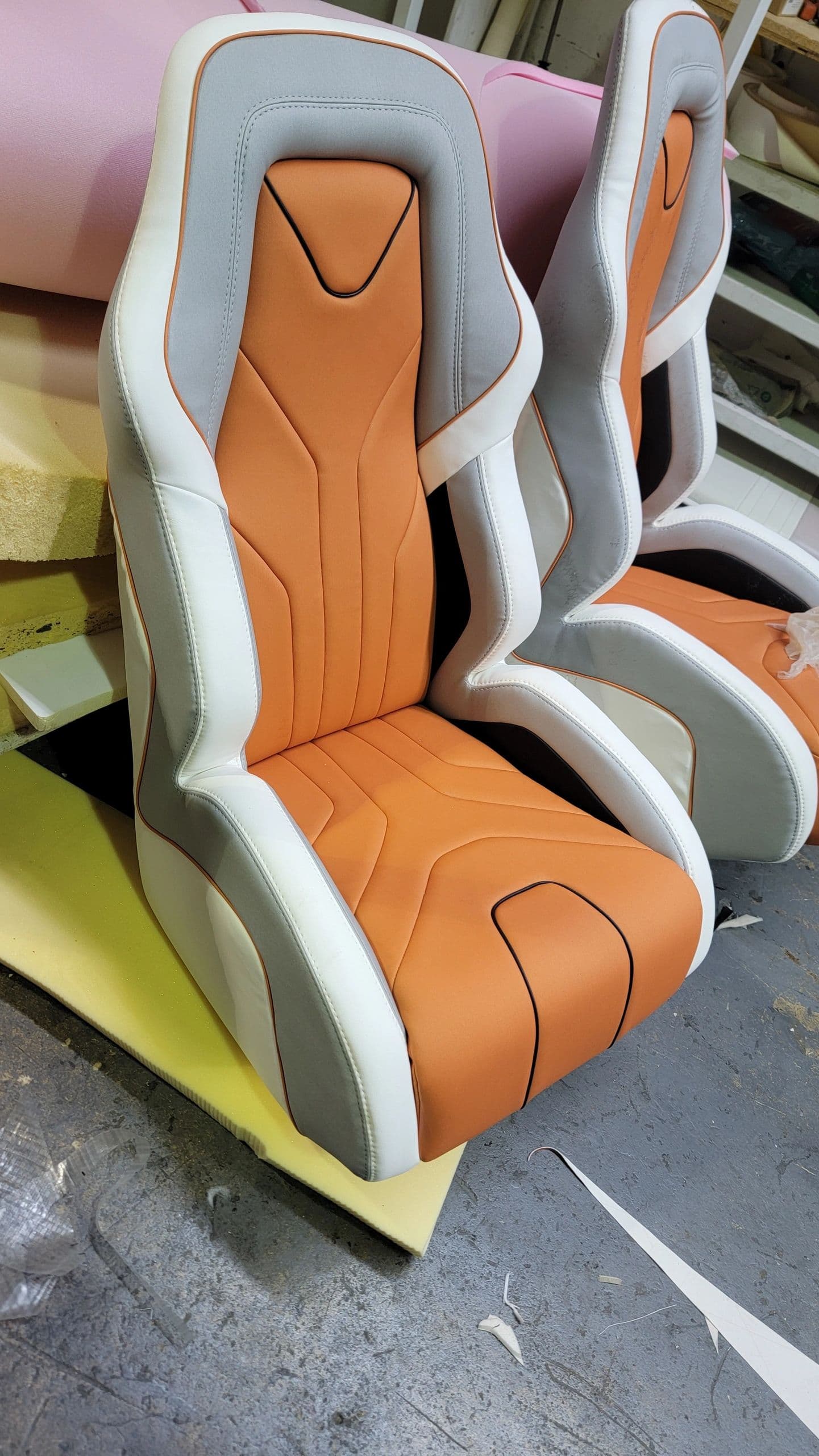 Pair of custom-stitched sport helm seats in the workshop
